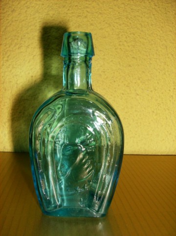 Klein glazen flesje met Hoefijzer in reliëf