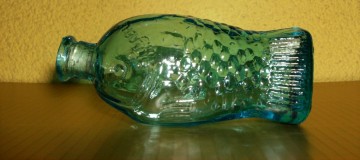 Klein glazen flesje met afbeelding van een Vis in reliëf